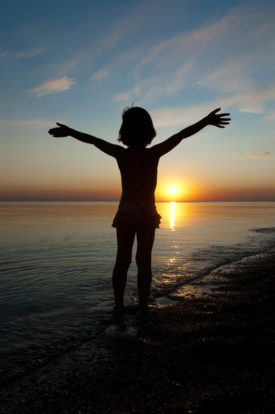Child silhouette on sunset beach, little girl having fun — Stock Photo, Image