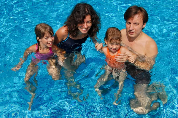 Felice famiglia attiva con bambini in piscina — Foto Stock