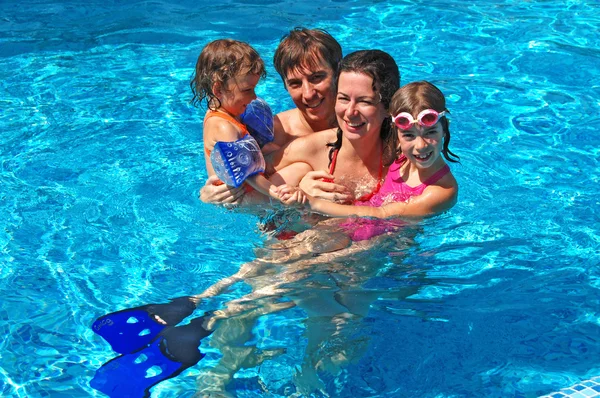 Счастливая активная семья с детьми в бассейне — стоковое фото