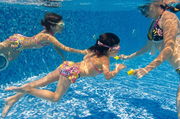 Active underwater family in swimming pool — Stock Photo, Image