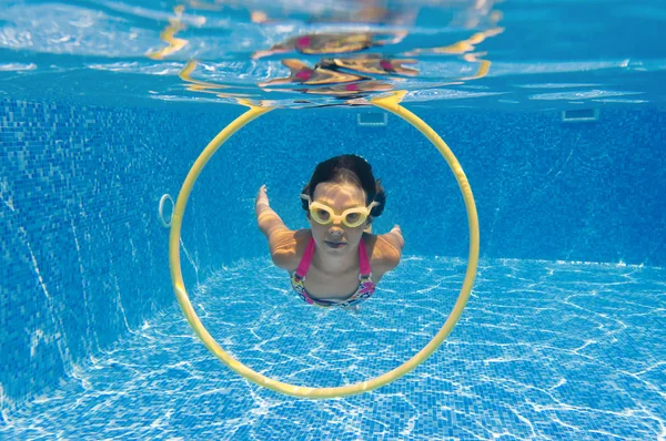 Gelukkig lachend onderwater kind in zwembad — Stockfoto