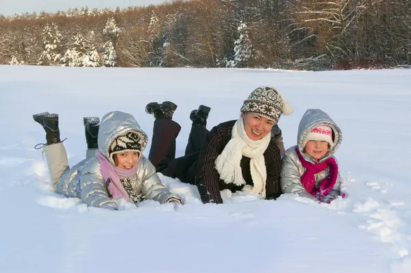 屋外の冬の雪の上で楽しんで幸せなアクティブな家族 — ストック写真