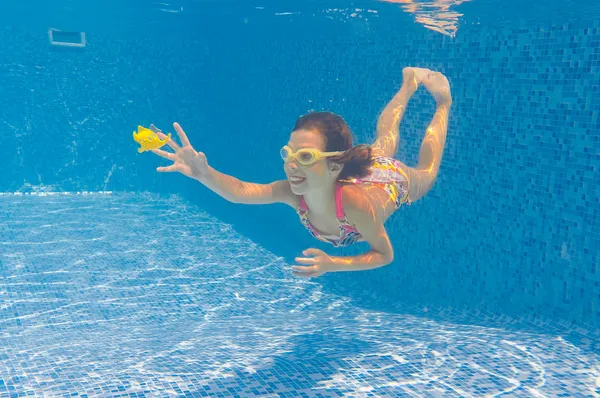 Criança feliz nada debaixo d 'água na piscina — Fotografia de Stock