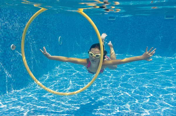 Lyckligt barn simmar under vattnet i poolen — Stockfoto