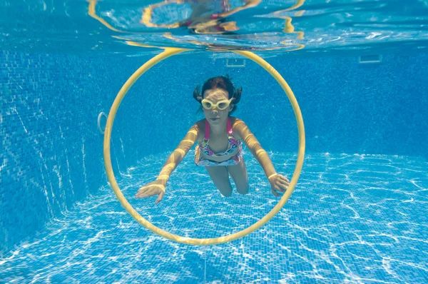 Happy child swims underwater in swimming pool — Stock Photo, Image