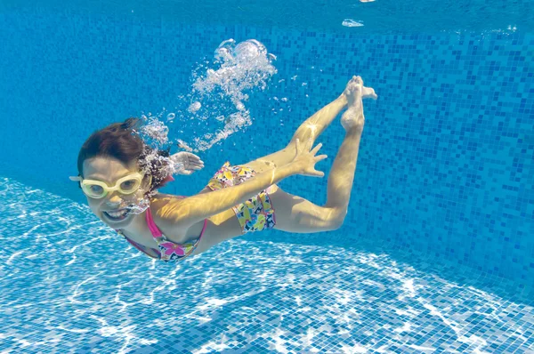 Счастливый ребенок плавает под водой в бассейне — стоковое фото
