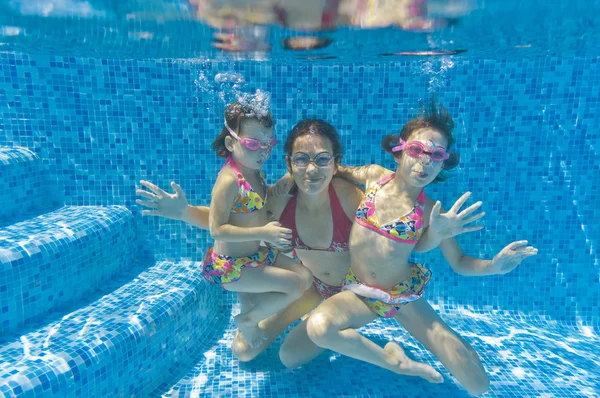 Unterwasser lächelnde Familie hat Spaß und spielt im Schwimmbad — Stockfoto