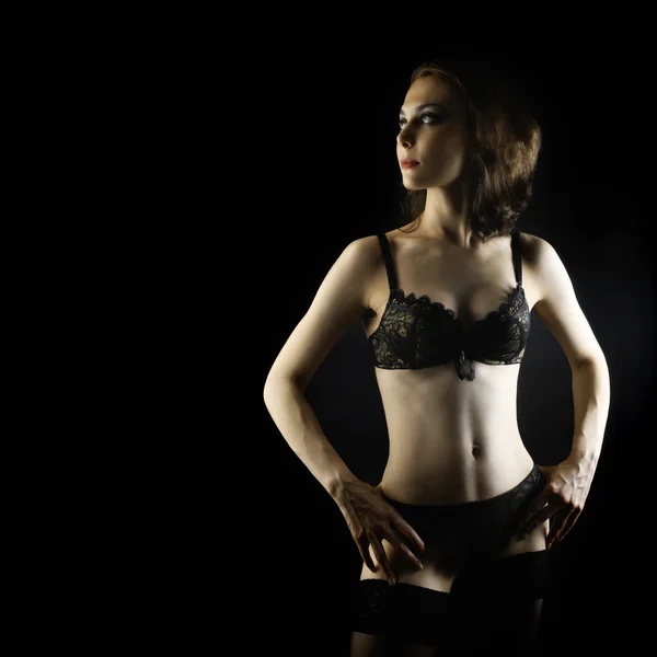 Sexy vrouw in lingerie op zwart. — Stockfoto