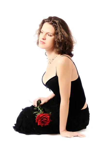 Красива мрійлива жінка з трояндою сидить — стокове фото