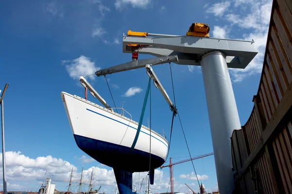 Sailboat lift up by a boat lifter — Stock Photo, Image