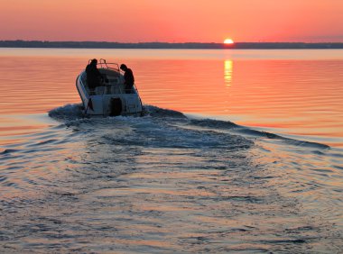 Speedboat in sunset clipart