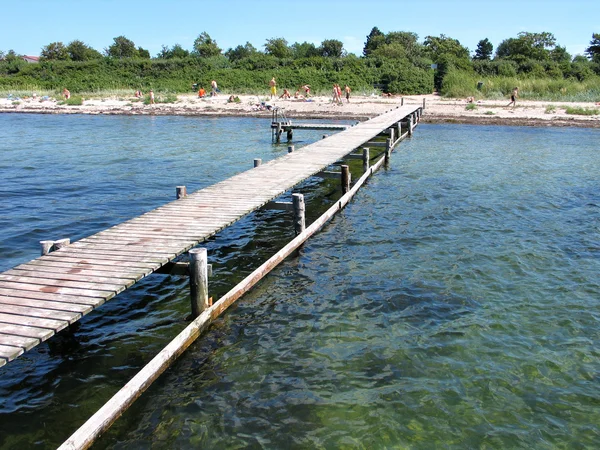 Beach fun - strand met een houten pier — Stockfoto