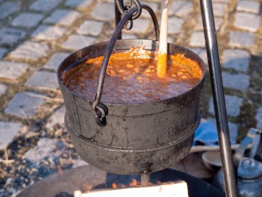 Cooking soup over burning campfire clipart