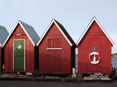 Beautiful red fishing huts on the coast clipart