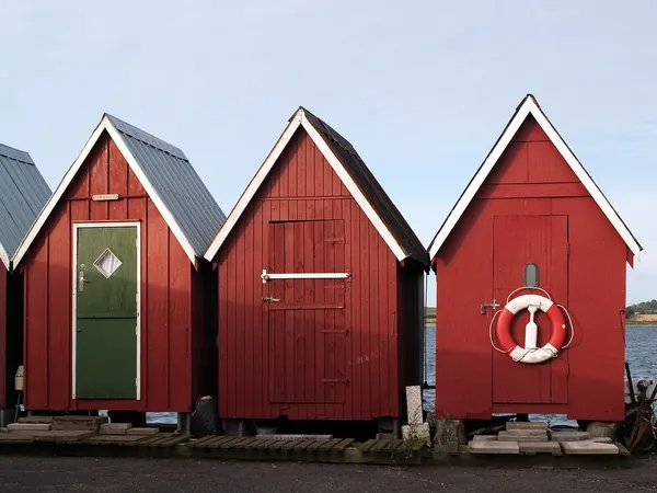 Belles cabanes de pêche rouges sur la côte — Photo