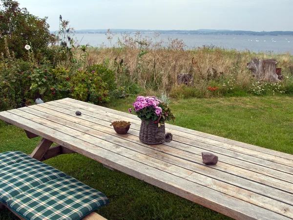Schöne Stillleben Korb mit Blumen auf einem Tisch — Stockfoto