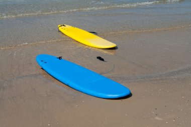 Surf boards on a sandy beach clipart