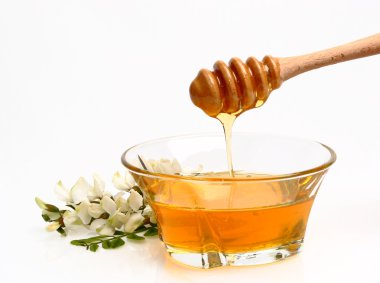 Honey pouring into glass pot clipart