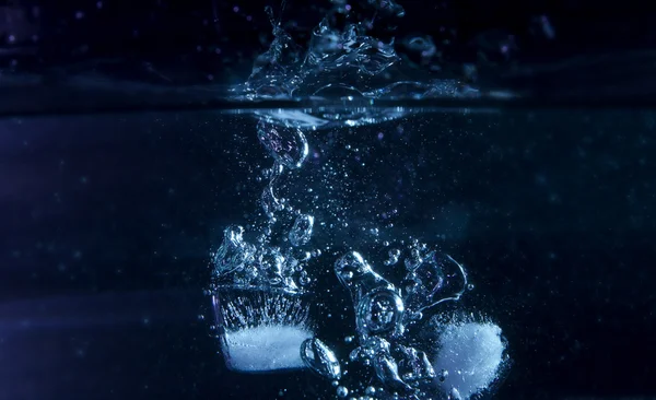 Eiswürfel ins Wasser Stockbild