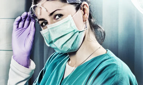Kvinnliga kirurgen i operationssalen Stockbild