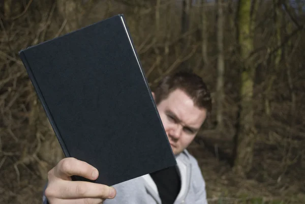 Мужчина держит книгу — стоковое фото