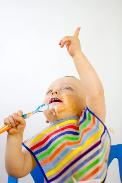 Bebés comida sobre la cara mientras que señala —  Fotos de Stock
