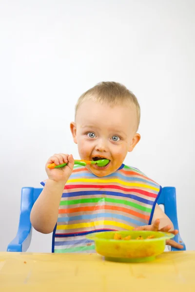 Baby zijn eerste maaltijden eten Stockfoto