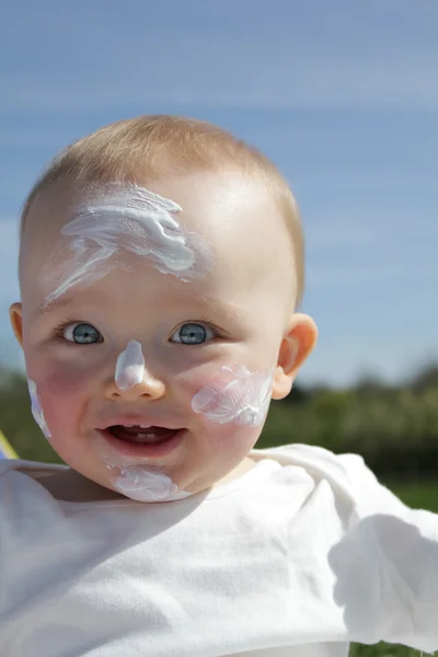 Bebê em blotchy protetor solar loção — Fotografia de Stock