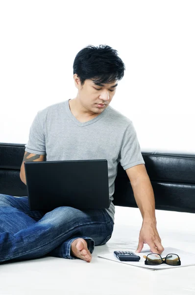Ung man sitter på golvet med laptop — Stockfoto