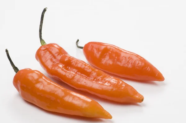 stock image Spicy hot green network and hot chili peppers over white