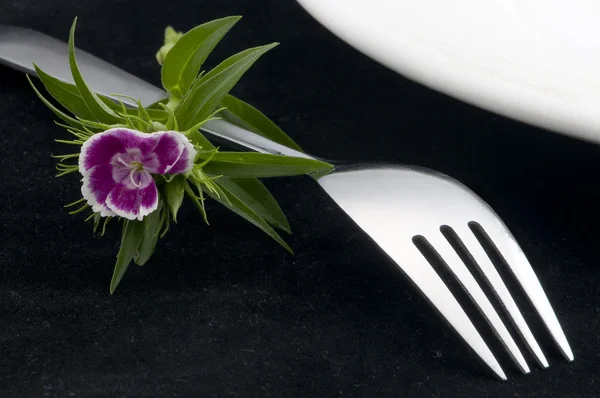 Forchetta su sfondo bianco con fiore — Foto Stock