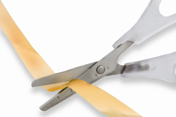 Yellow tape cutting scissors on a white background — Stock Photo, Image