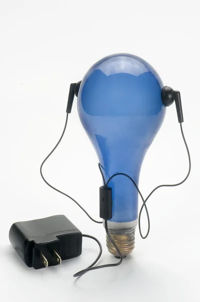 Blue bulb and plug headphones — Stock Photo, Image