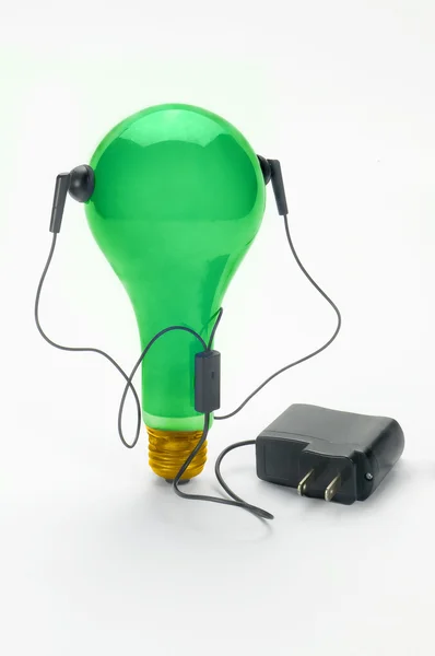 Grønn lyspære og hodetelefoner – stockfoto