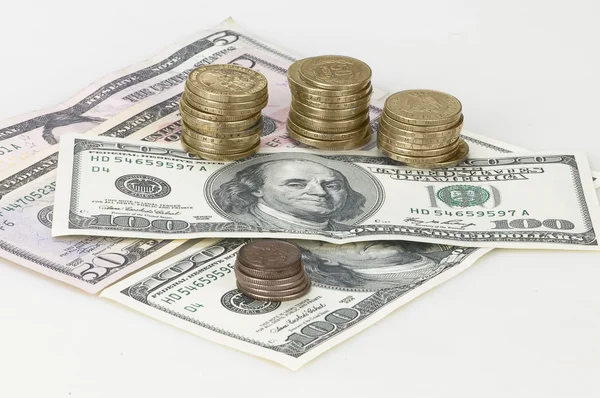 Moedas e dólares sobre fundo branco — Fotografia de Stock