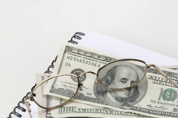 Dollars with glasses and notebook — Stock Photo, Image