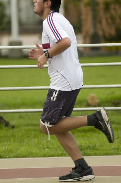 Homem adulto correndo na pista de atletismo — Fotografia de Stock