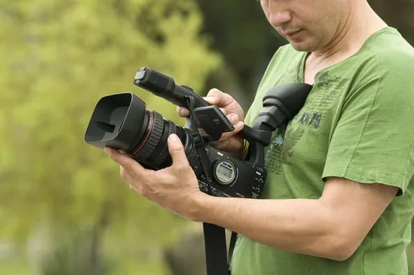 El hombre con la cámara de vídeo en las manos Imagen de stock