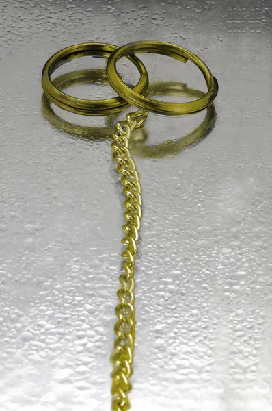 Dva zlaté snubní prsteny s řetízkem — Stock fotografie