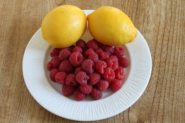 Raspberries and lemons — Stock Photo, Image