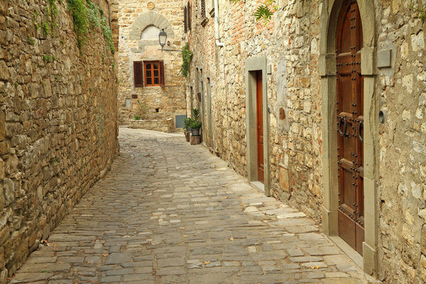 Narrow paved street and stone walls in italian village, Montefioralle, Tuscany, Italy, Europe