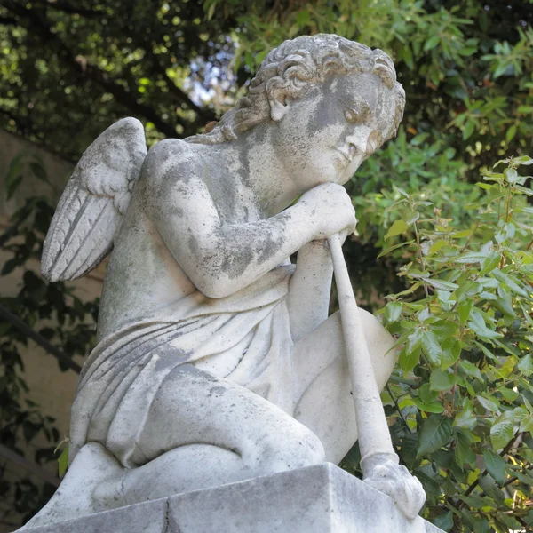 Skulptur kniender Engel mit Flöte auf Friedhof Stockbild