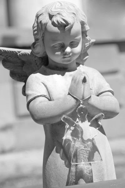 Cemetery angel holding glass angel toy — Stock Photo, Image