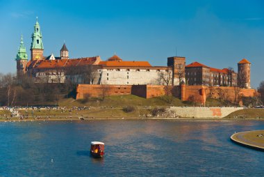 Wawel castle and gondola floating on the Vistula river in Cracow, Poland clipart