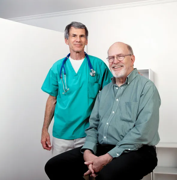 Glad läkare med happy senior manlig patient — Stockfoto