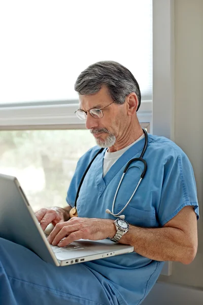Doktor pracuje na notebooku sedí na podlaze — Stock fotografie
