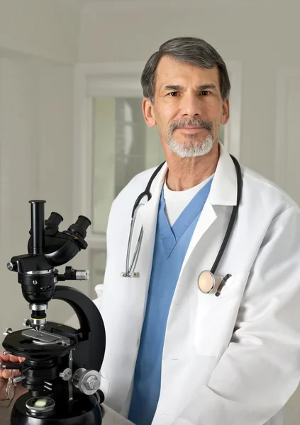 Médico ou cientista no microscópio — Fotografia de Stock