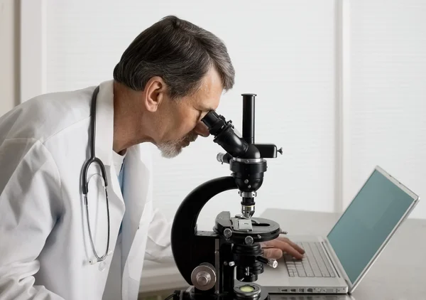 Доктор или ученый в микроскопе — стоковое фото