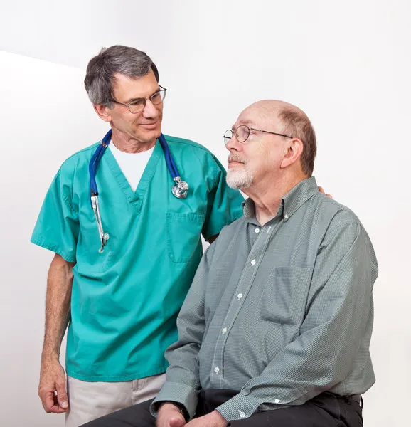 Arts of verpleegkundige geruststellend senior mannelijke patiënt — Stockfoto