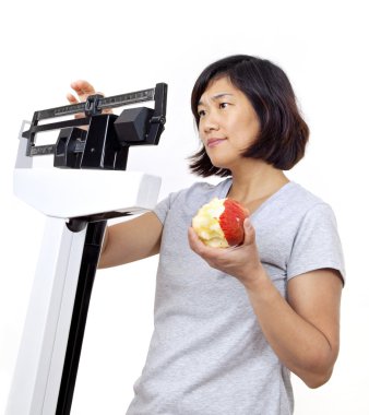 Woman with Apple on Scale Worried About Weight Gain clipart